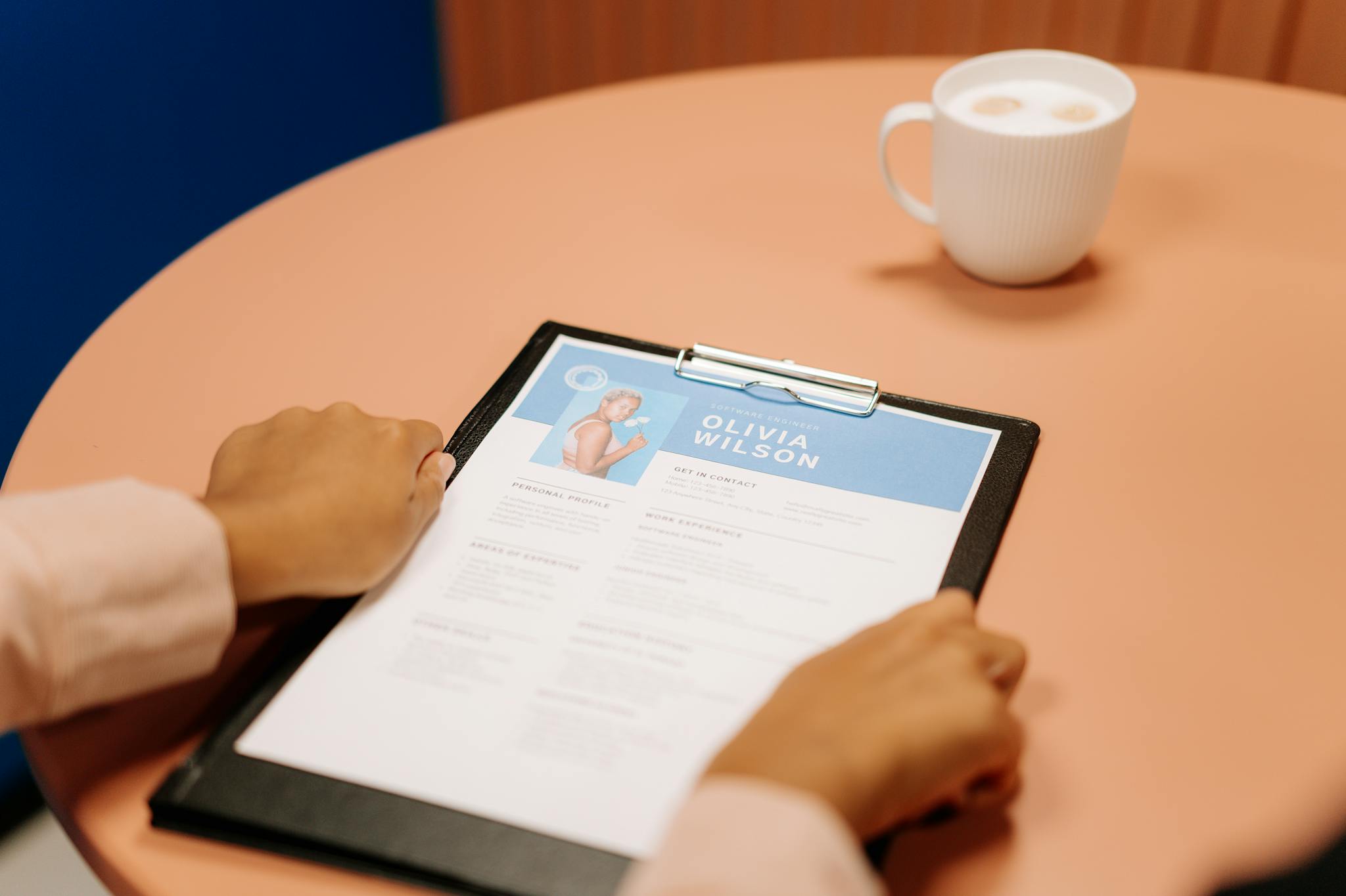 Professional reviewing a resume with coffee on the table — resume writing tips by CareerBizBoost